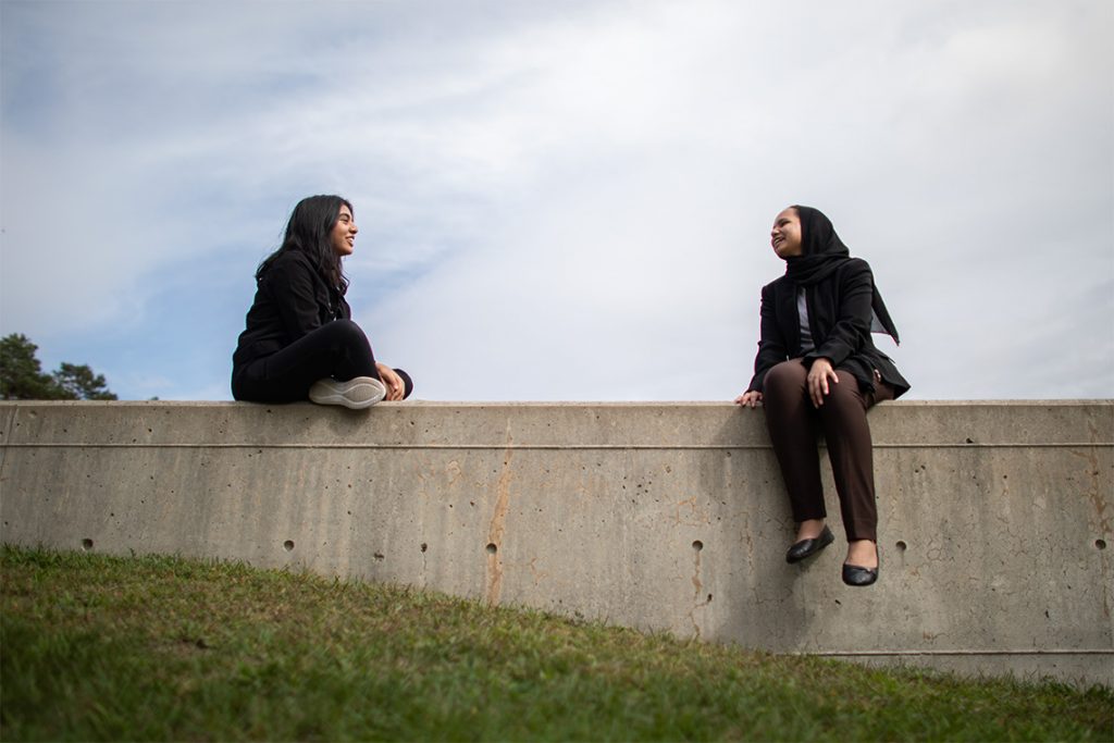 Maha Khan and Maimuna Akhter sitting outside