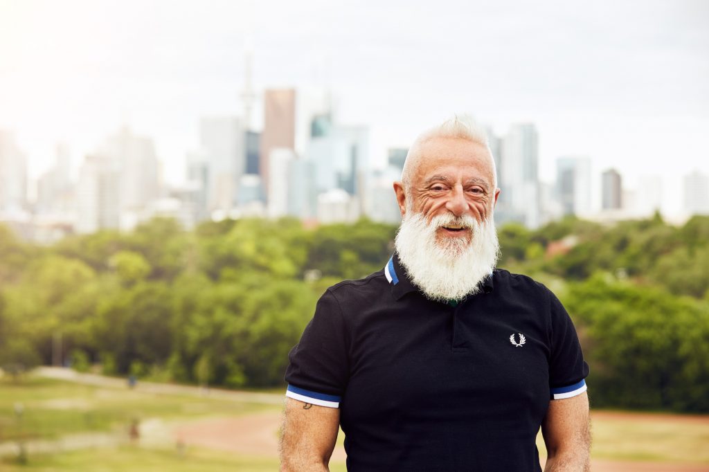 portrait of Francisco in a short sleeved dark polo shirt standing in front of a Toronto skyline