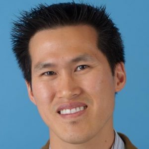 head shot of Patrick Feng smiling, blue background