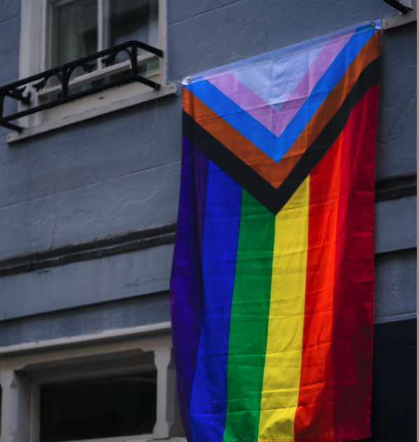 Pride flag hanging from building, triangle colours