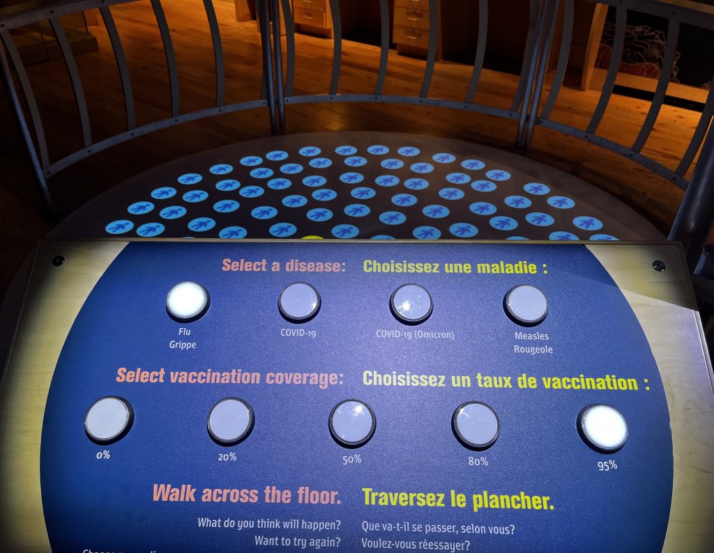 A panel with buttons on it and a series of dots on the floor behind it.