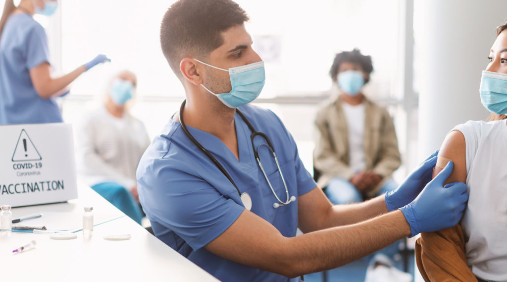 Image of a patient receiving a bandaid from a nurse after their COVID vaccination