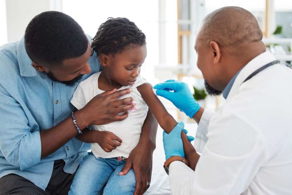 A doctor vaccinating a young child, illustrating how measles vaccines protect many people