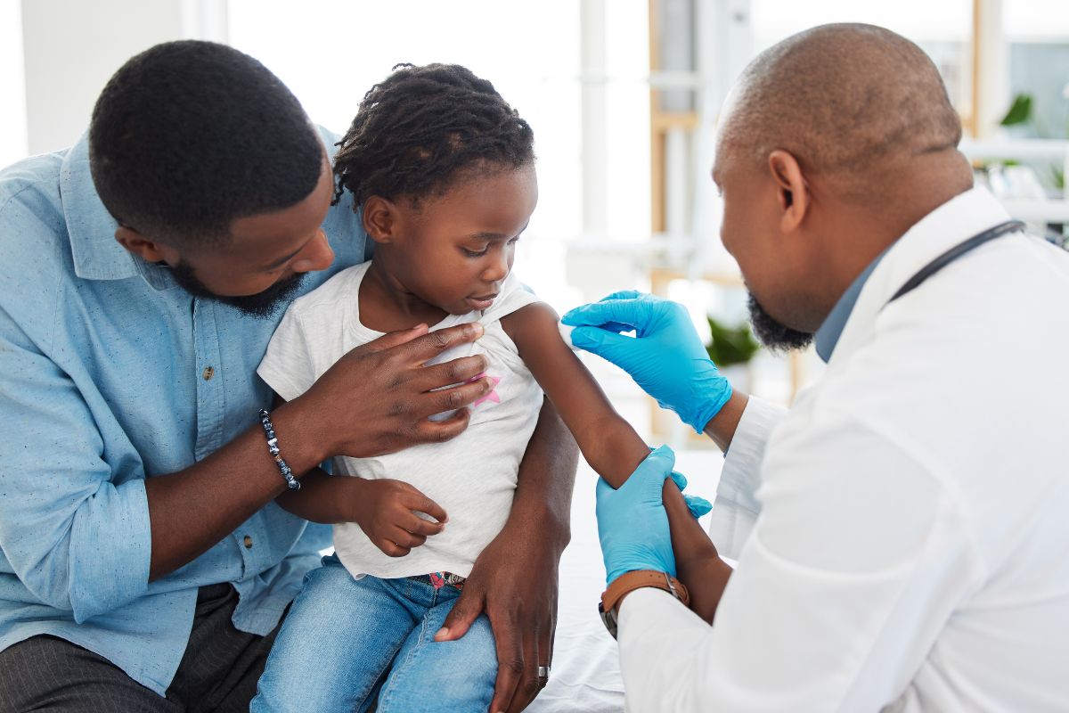 A doctor vaccinating a young child, illustrating how measles vaccines protect many people
